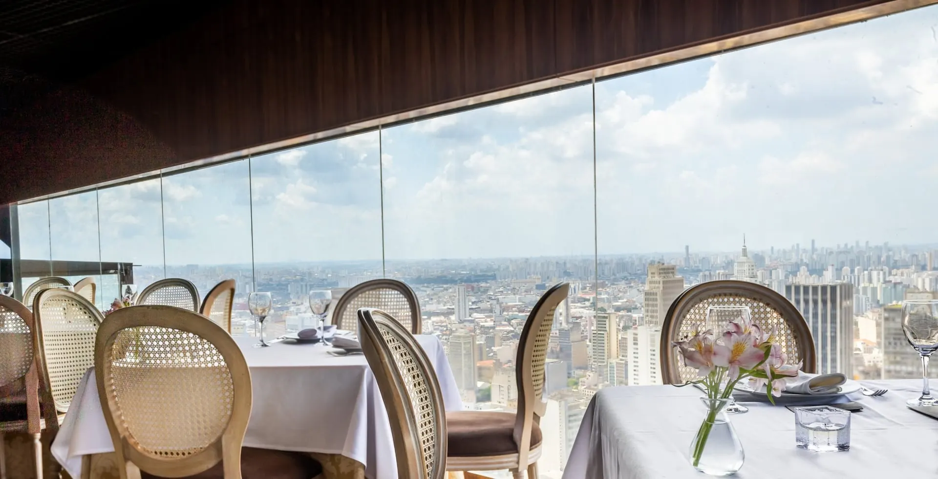 De zaal van Terraço Itália overdag, met tafels aan het raam en São Paulo op de achtergrond